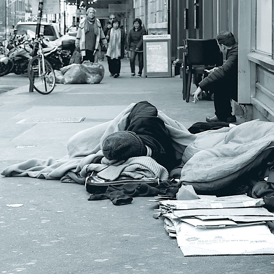 homeless man asleep on pavement